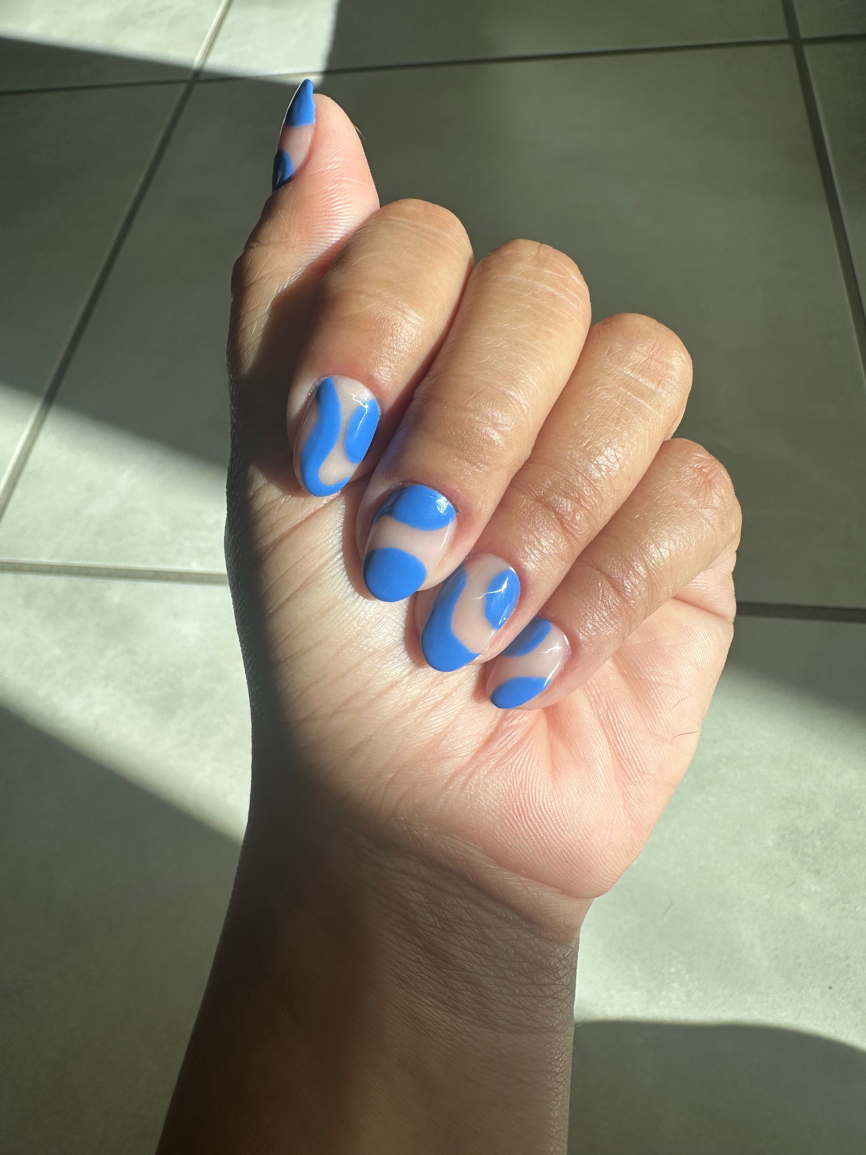 Acrylic nail manicure with blue nail art.
